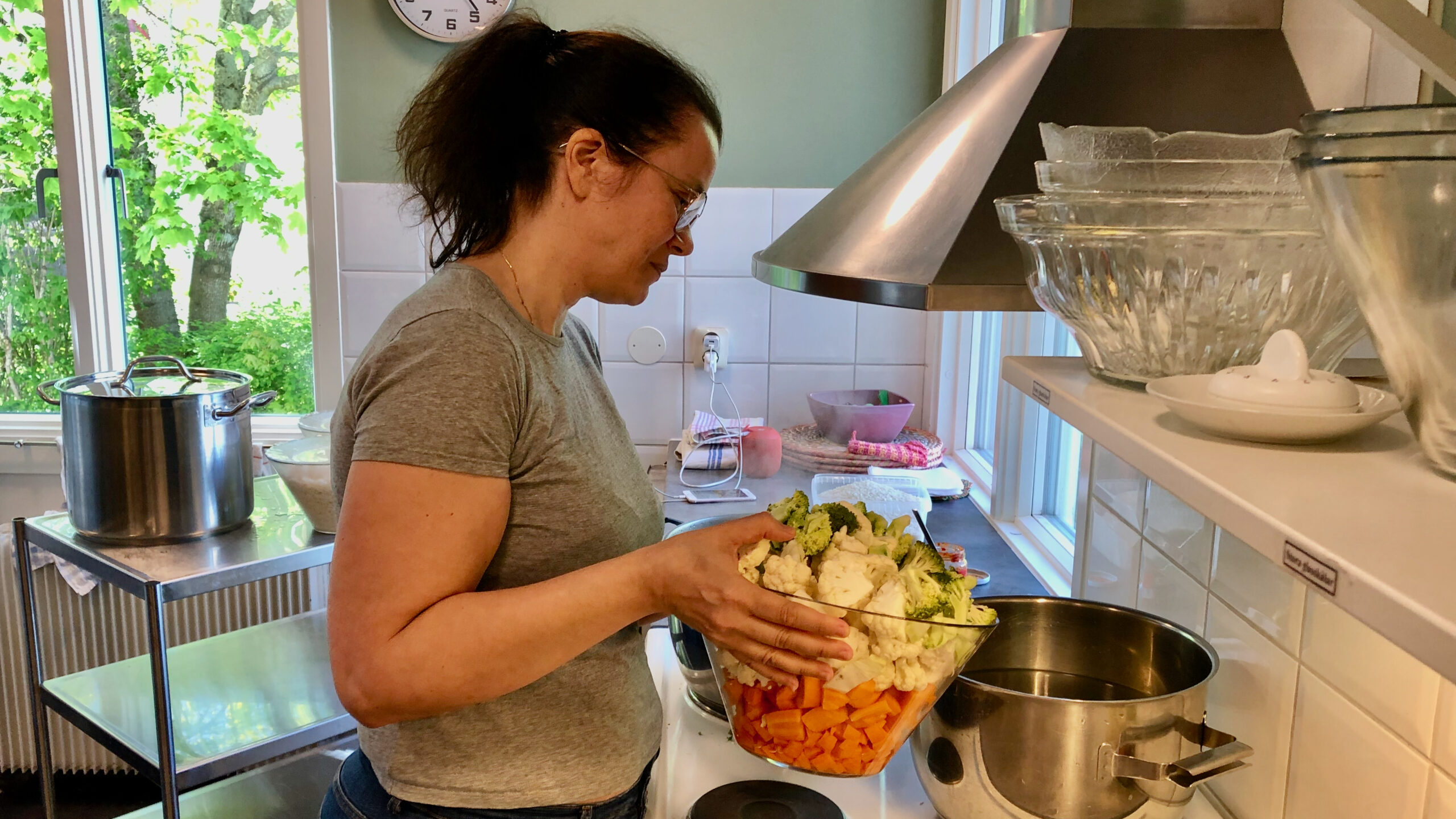 Kvinna häller grönsaker i soppkastrull